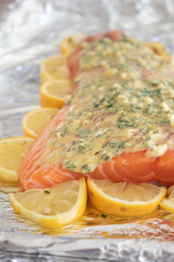 salmon lined with lemon slices and topped with herb marinade