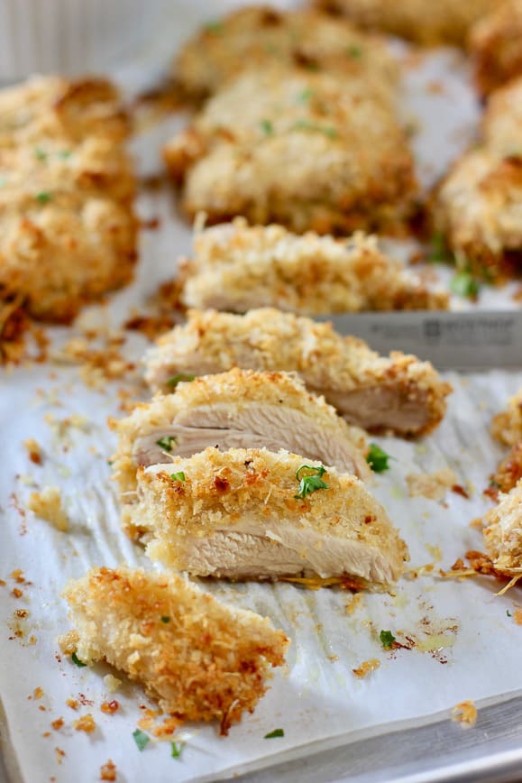 sliced baked chicken thighs on a sheet pan with parchment