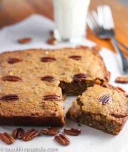 Pecan Snack Cake served up on parchment paper with glass of milk