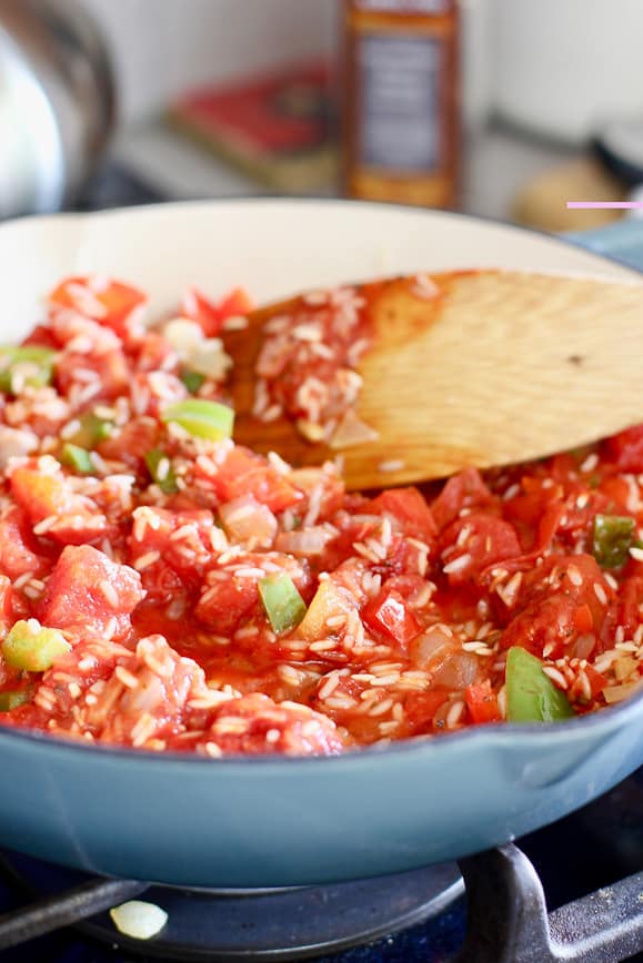 After tomatoes and broth are added to the rice, simmer, cover and cook 