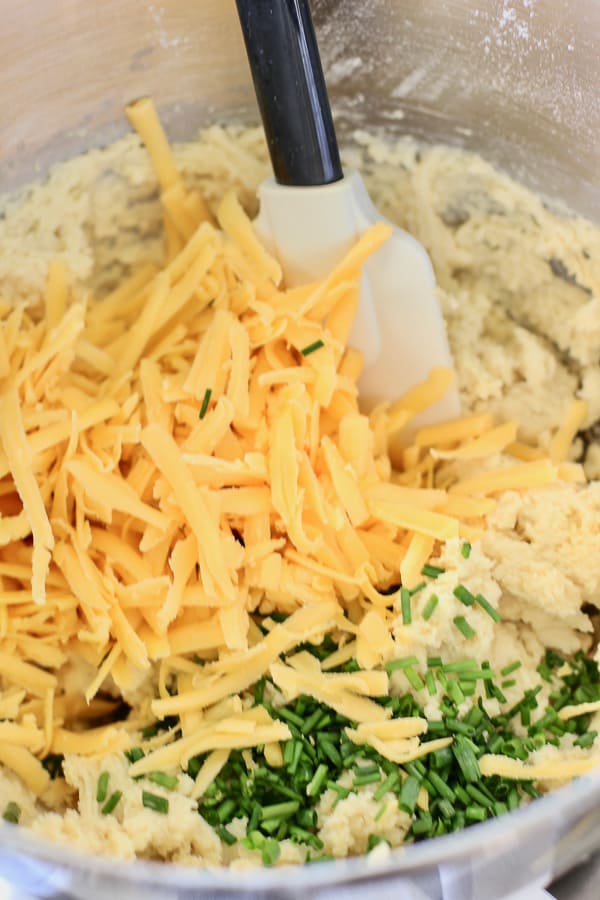 cheddar and chives being mixed into scones