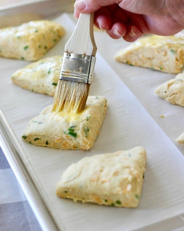 egg wash being brushed onto scones