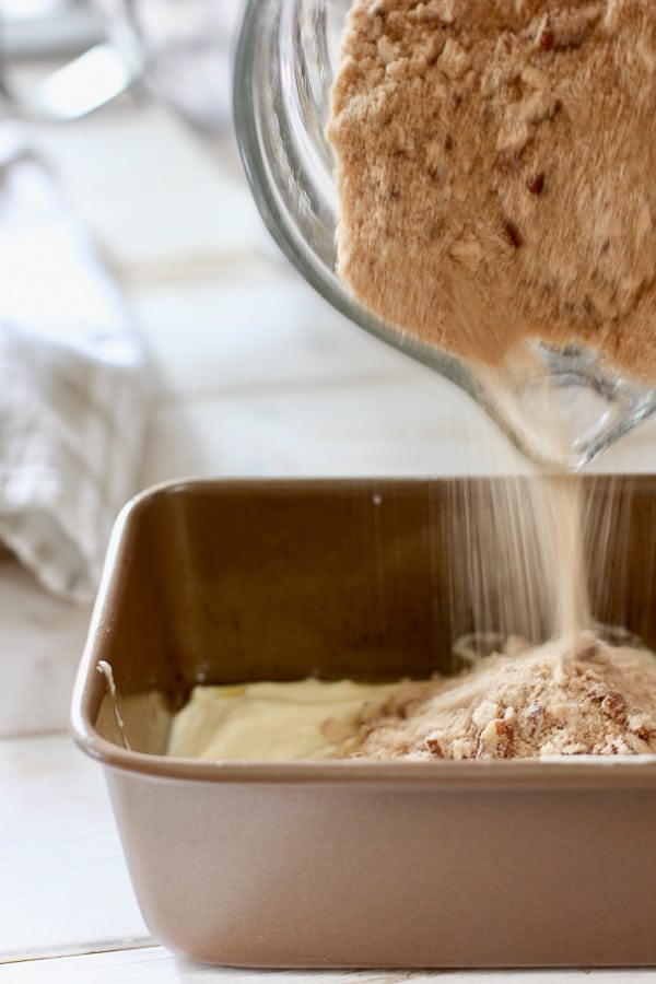 delicious streusel topping being poured onto coffee cake