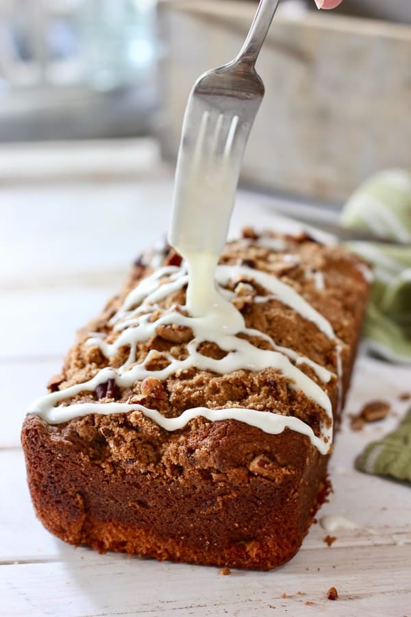 icing being drizzled onto coffee cake with a fork