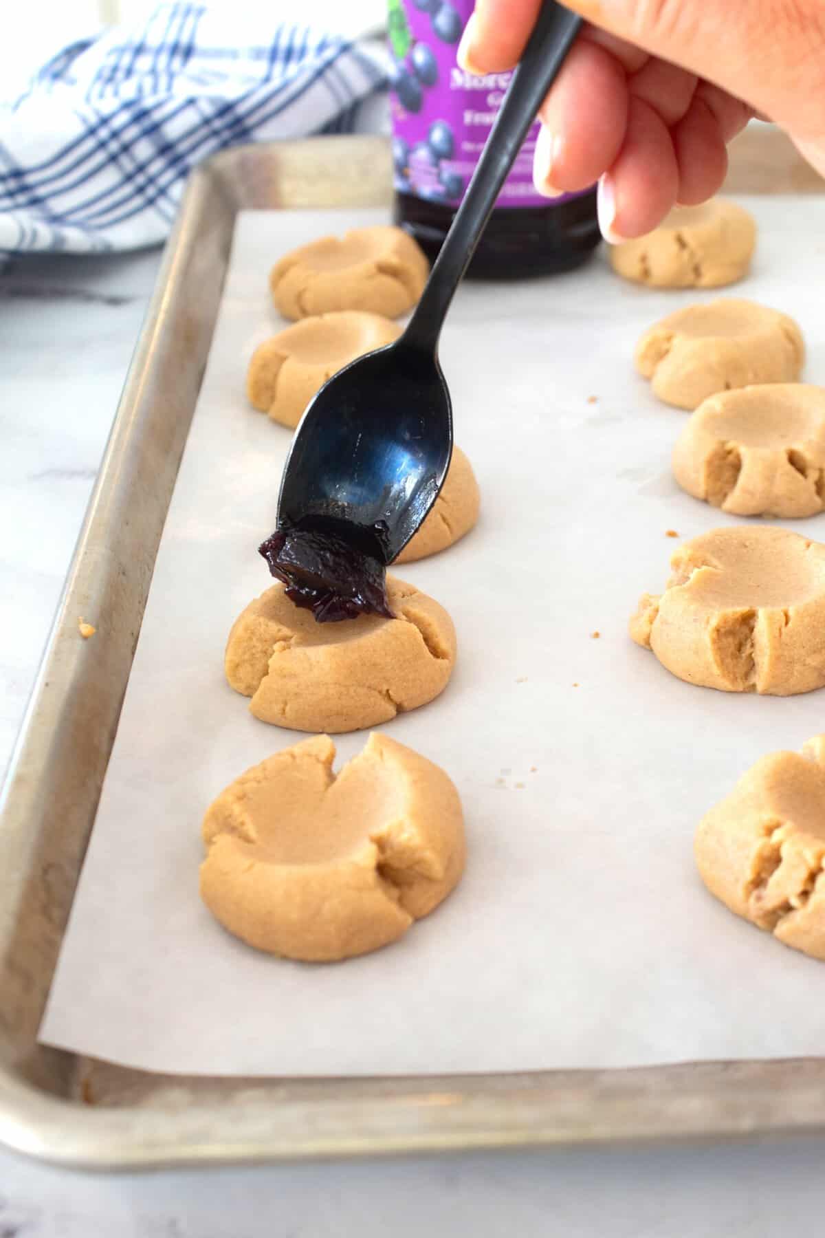 spooning jelly into cookie
