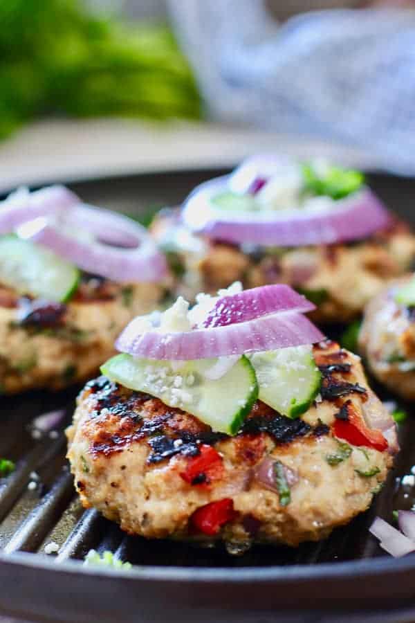 greek chicken burger with cucumber on a grill pan