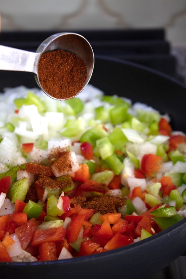 adding chili powder to taco meat