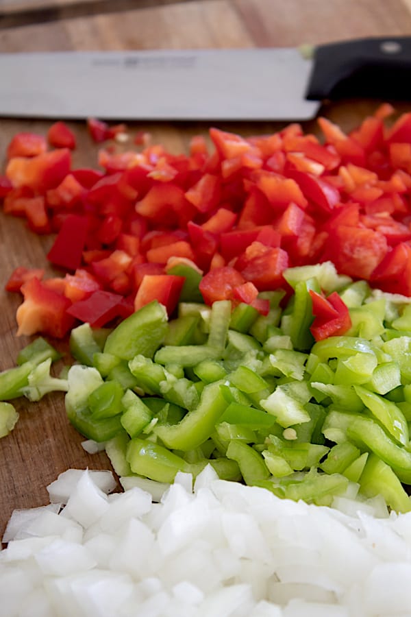 chopped onions and peppers on a cutting board
