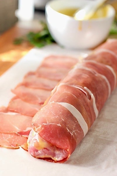 wrapping prosciutto around a pork loin