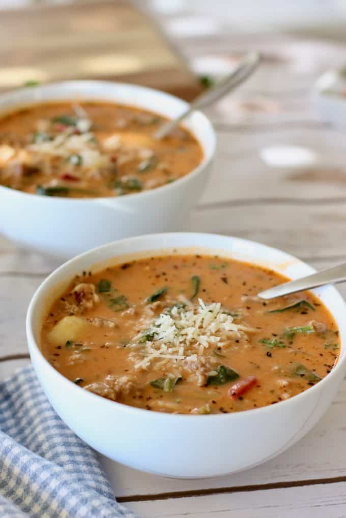 Sausage soup in white bowls with spoon