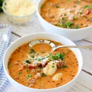 Gnocchi Sausage soup in white bowls with spoon