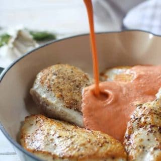Creamy Red Pepper sauce poured over chicken breasts