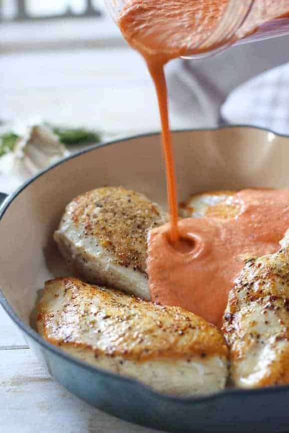 Creamy Red Pepper Sauce poured over seared chicken breasts