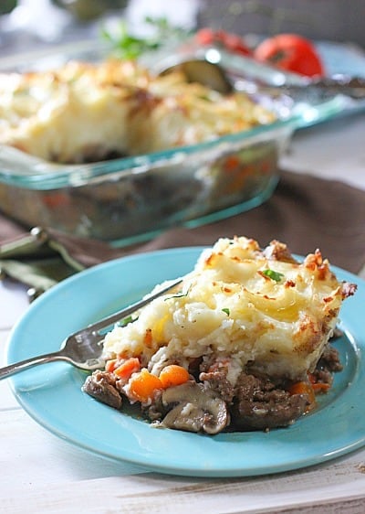 Shepherds Pie served on a blue plate with a fork, ready to eat. 