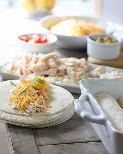 Enchiladas Verde being wrapped in tortillas