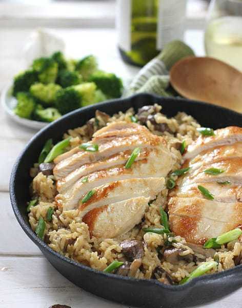Sliced chicken over rice in cast iron skillet
