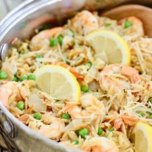shrimp and orzo with sliced lemons in a skillet
