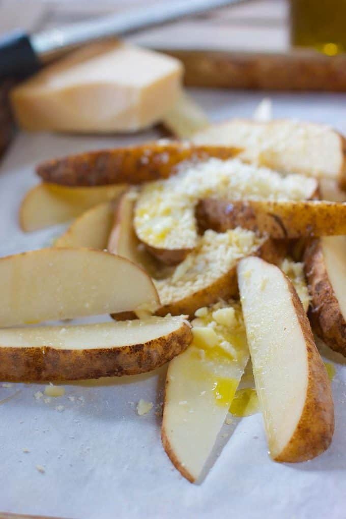 Coating potato wedges with olive oil and cheese