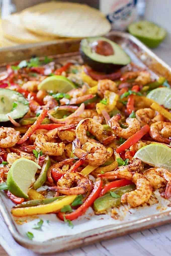 shrimp and sliced veggies on a tray for shrimp fajitas