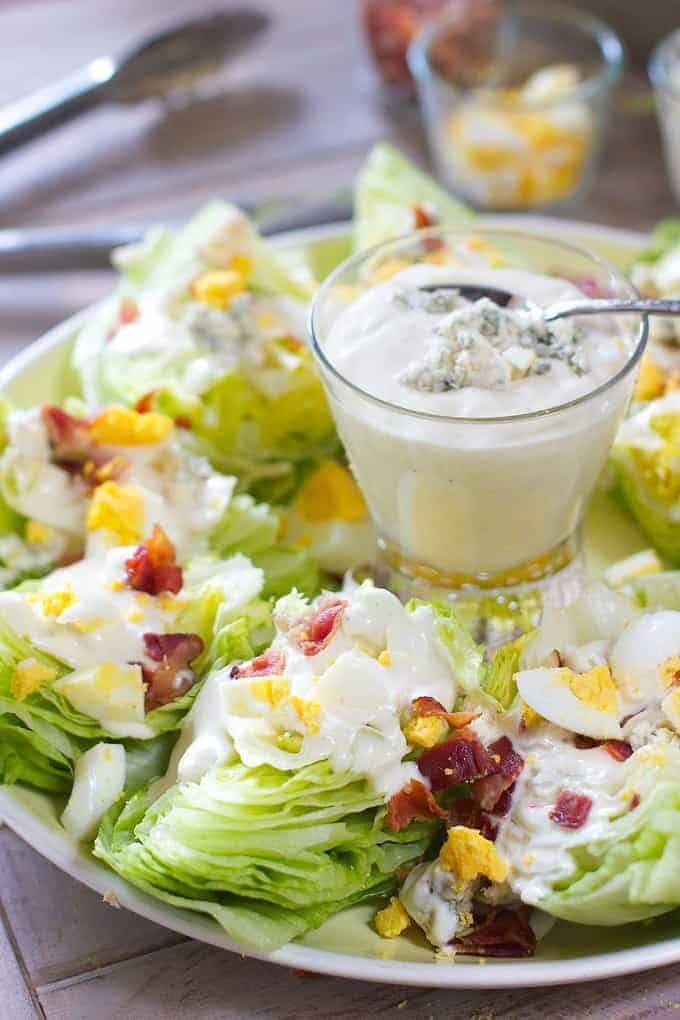 Wedge salad on a green platter with dressing