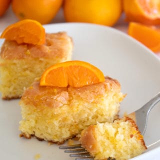 orange brownies on a white plate with tangerines in back ground