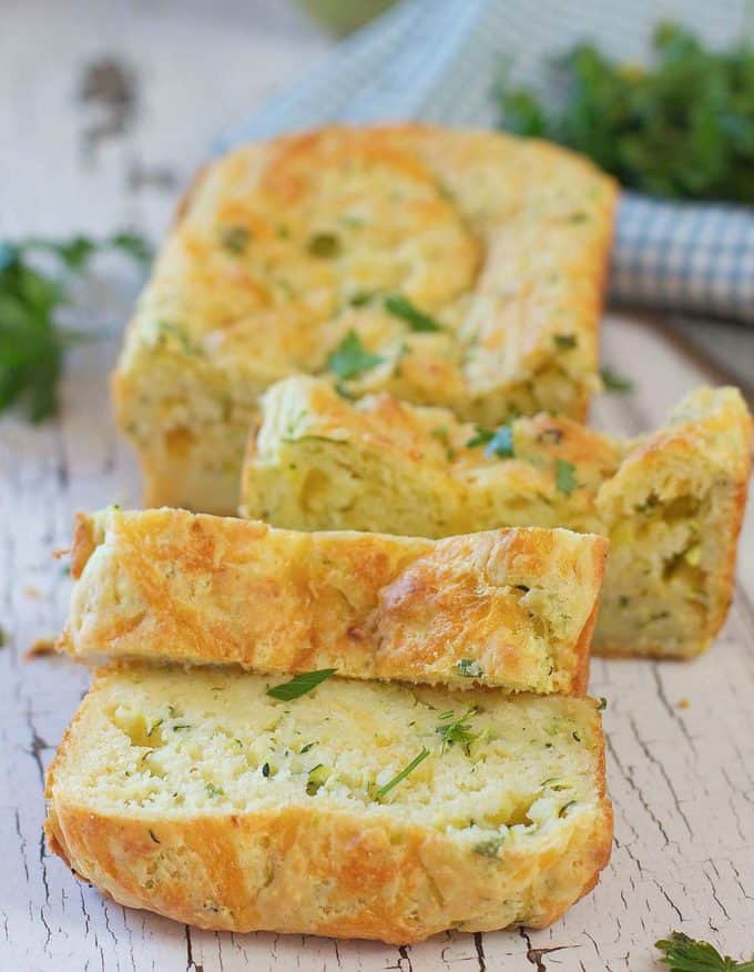 warm zucchini and cheddar bread sliced on a white board