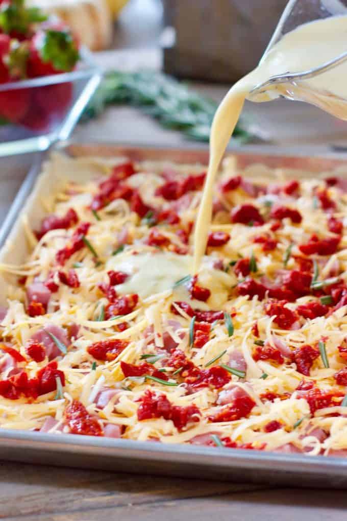 pouring egg on to Sheet Pan Quiche