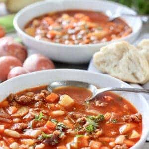 A bowl of chorizo and white bean soup garnished with parsley