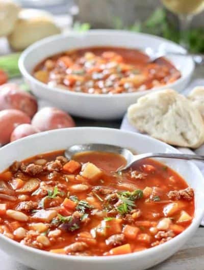 A bowl of chorizo and white bean soup garnished with parsley