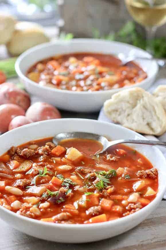 A bowl of chorizo and white bean soup garnished with parsley