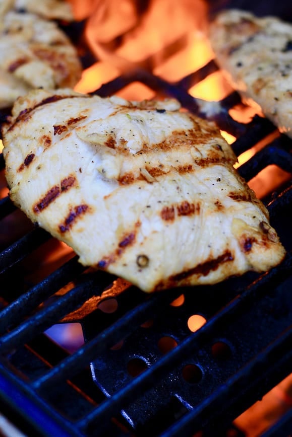 Lemon Grilled Chicken on the BBQ with grill marks and a flame in the background