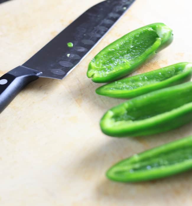 Jalapeños on a cutting board getting ready to be sliced. Removed the seeds fully for less heat.