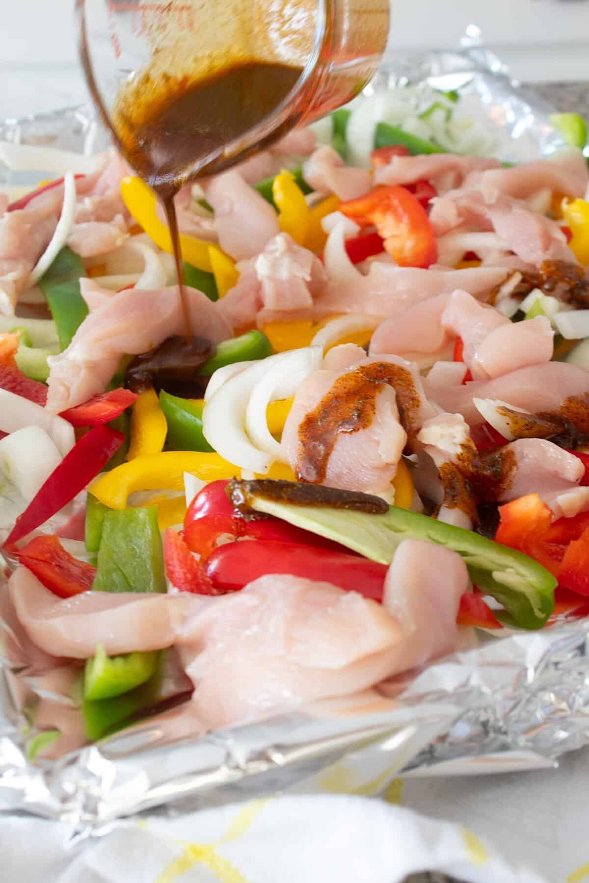 pouring marinade onto sheet pan fajitas
