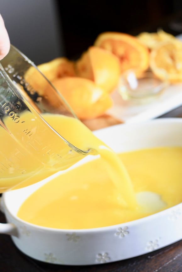 Pouring orange juice and honey mixture into a shallow dish