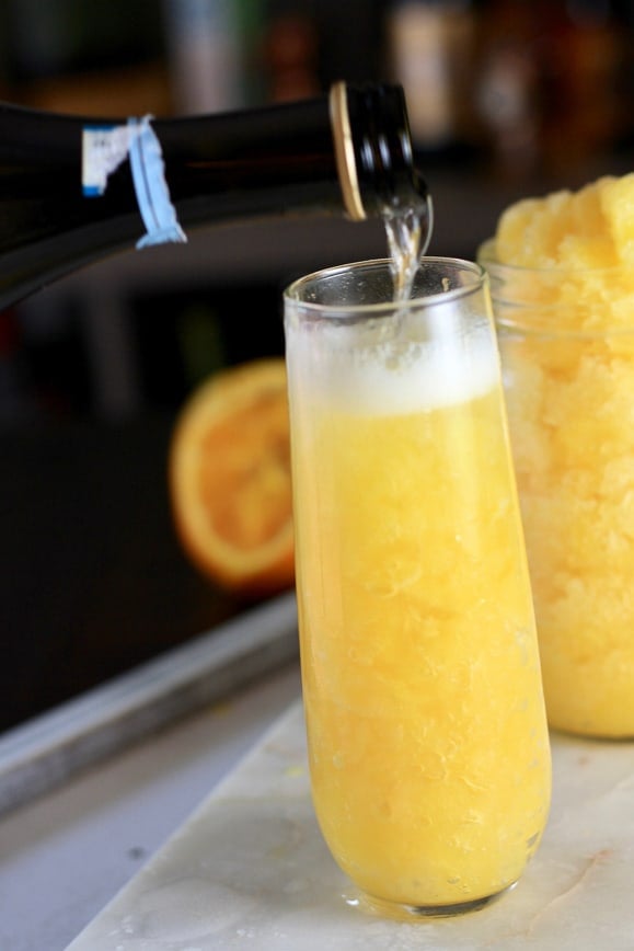 Prosecco being poured onto frozen orange juice mixture