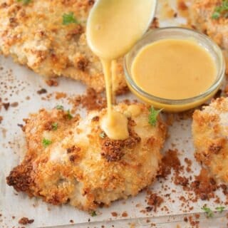 drizzling honey mustard onto crispy chicken thigh