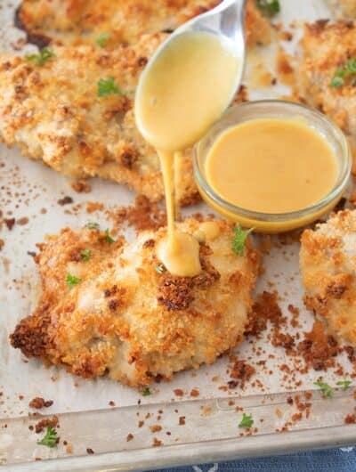 drizzling honey mustard onto crispy chicken thigh
