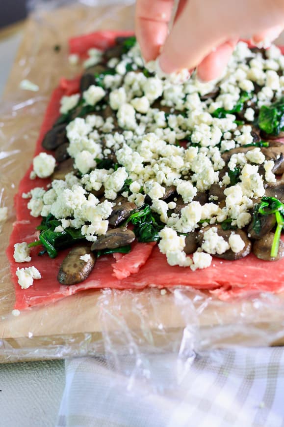 A flank steak pounded flat with mushrooms, spinach and blue cheese on top.