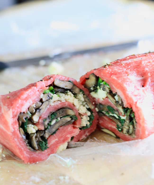 A sliced flank steak roll stuffed with mushrooms, blue cheese and spinach.