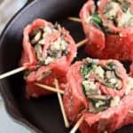 A cast iron pan filled with flank steak stuffed with bleu cheese and spinach