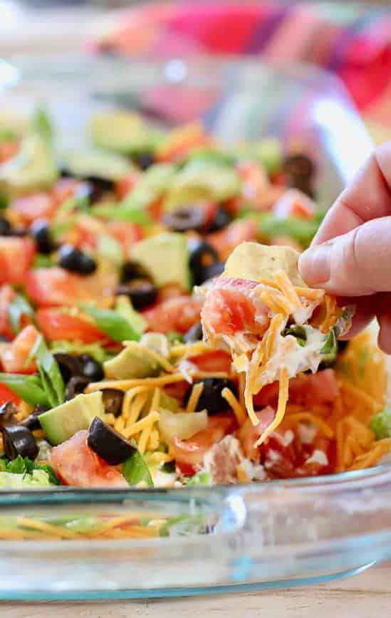 Skinny Taco Dip being scooped up with a tortilla chip