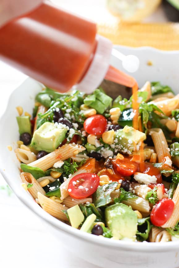 Adding dressing to Tex Mex Pasta Salad