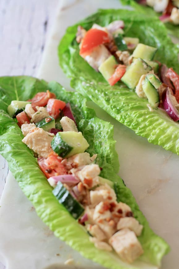 A romaine lettuce wrap stuffed with a chicken and veggie mixture dressed in homemade yogurt dressing