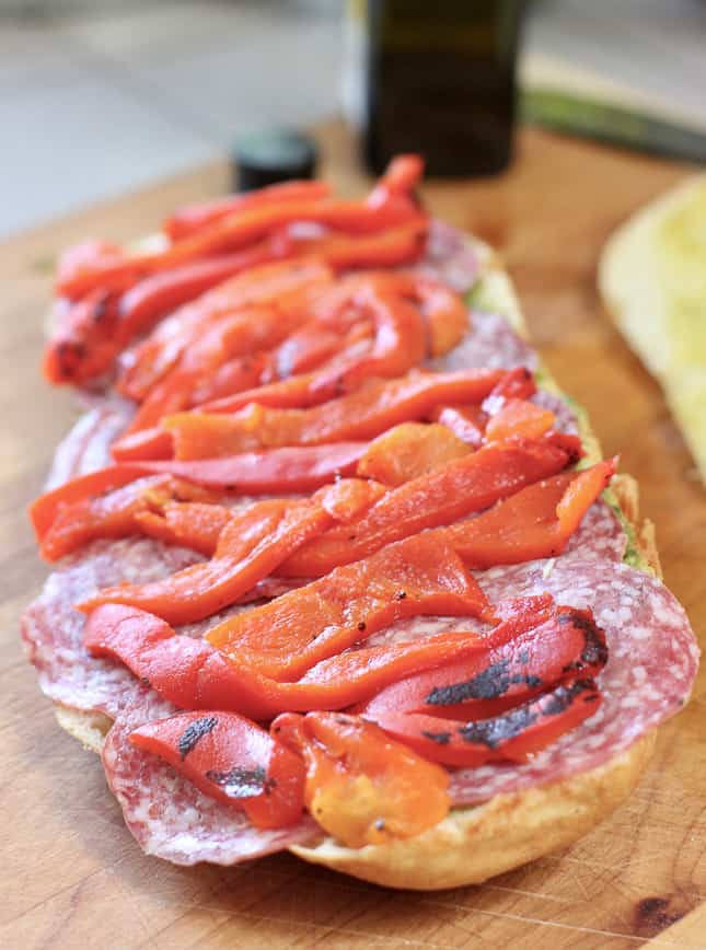 layers of salami and red pepper on foccacia bread