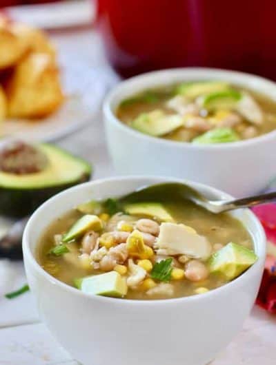 two bowls of white chicken chili with a spoon