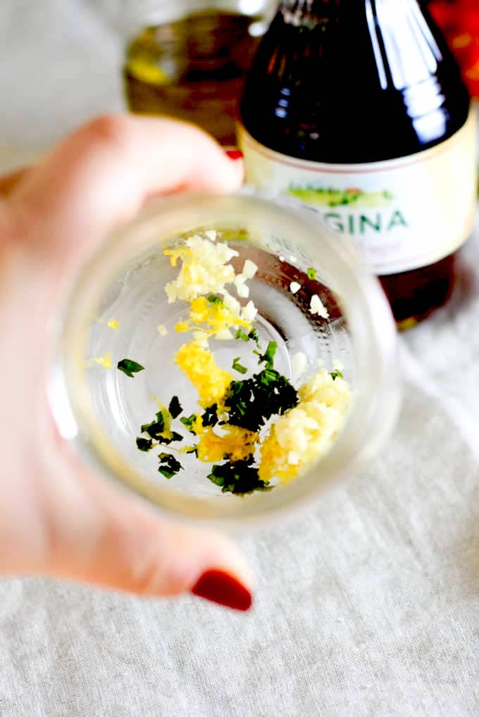 showing lemon zest, garlic and basil in mason jar for dressing