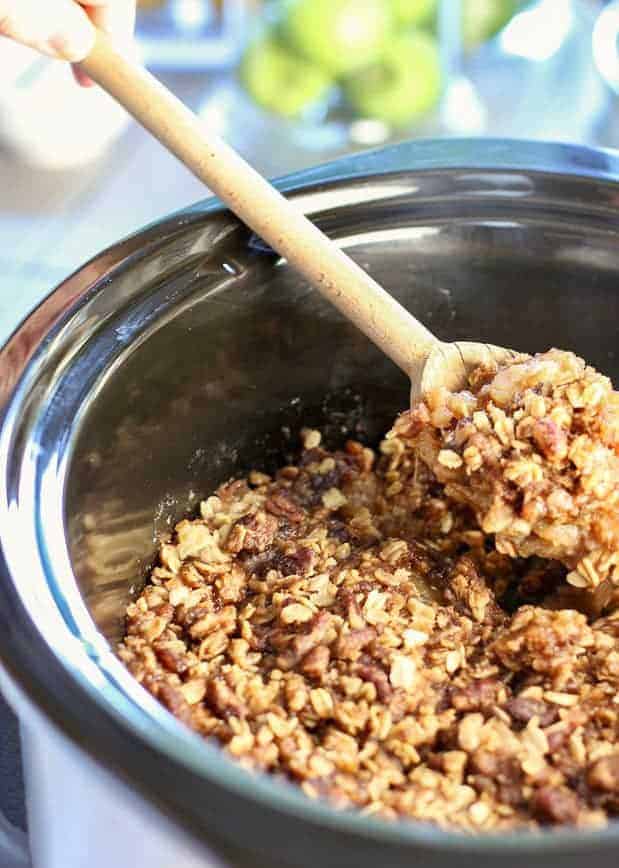 slow cooker apple crisp being served out of the crock pot