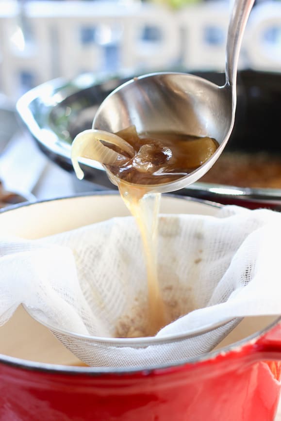 Chicken Pho being strained through cheese cloth