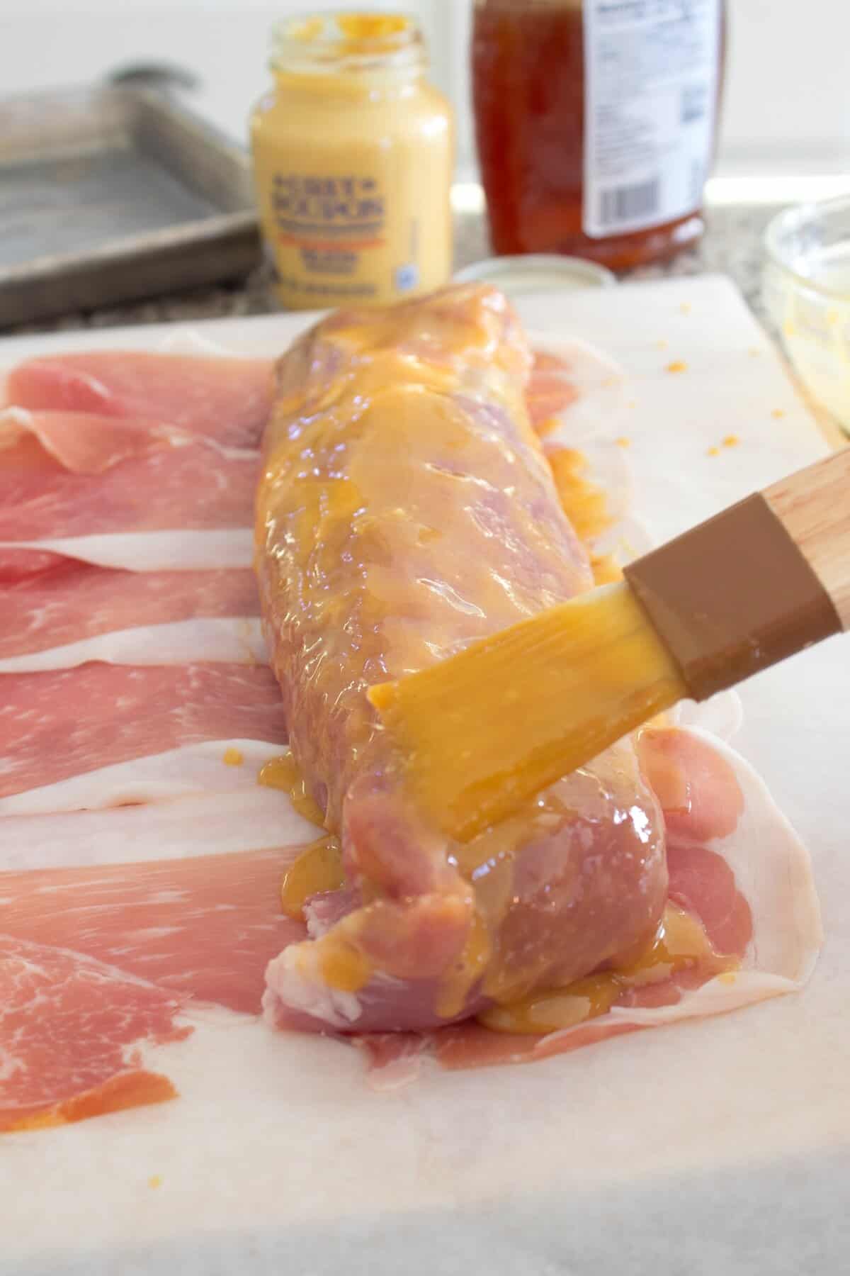 slathering pork tenderloin with honey mustard sauce