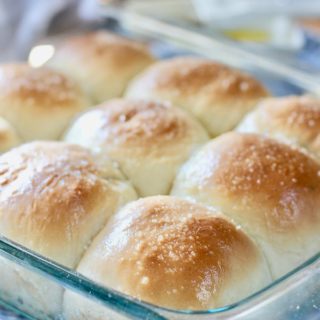 homemade rolls in a glass pan on a checkered cloth
